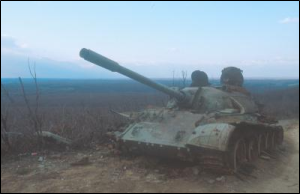 A ruined tank sitting on a road