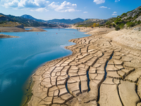 Aerial view of depleted Lago Azul reservoir serving the Southern Aldurian Riviera
