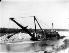 A floating steam shovel dredging the canal